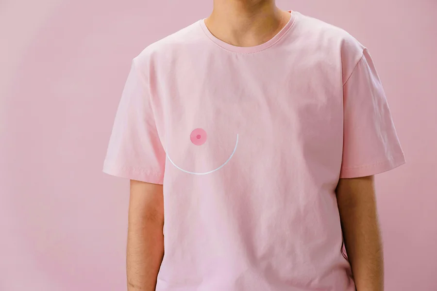 woman wearing a pink shirt with a stylized graphic depicting breast cancer